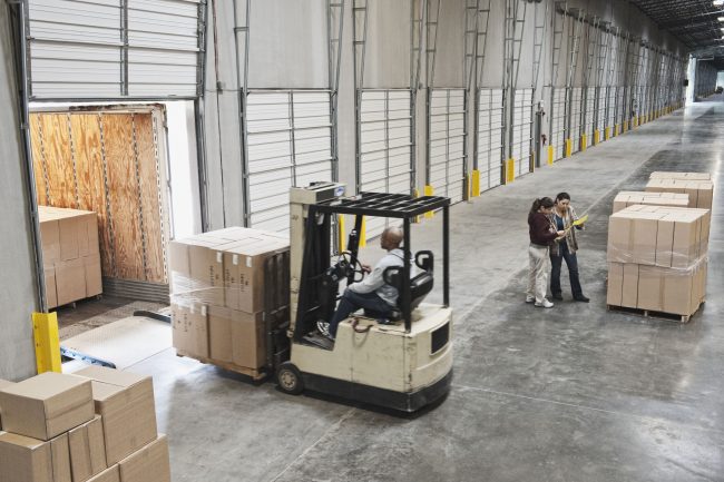 95699026 – forklift moving boxes onto truck at loading dock of warehouse